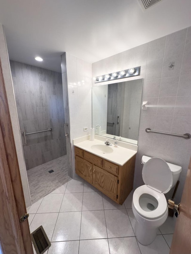 full bathroom featuring tile walls, tile patterned floors, visible vents, toilet, and walk in shower