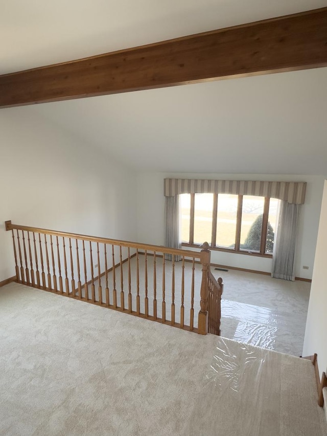 corridor with vaulted ceiling with beams, carpet flooring, and baseboards