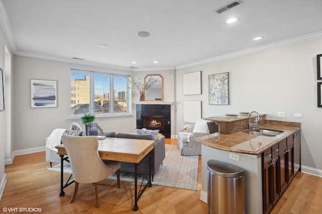 interior space with sink, crown molding, and light hardwood / wood-style floors