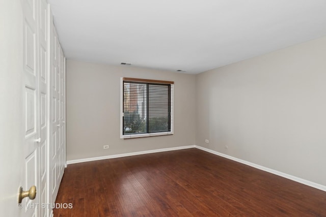 spare room featuring dark wood-type flooring