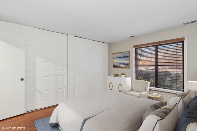 bedroom with hardwood / wood-style flooring and multiple windows