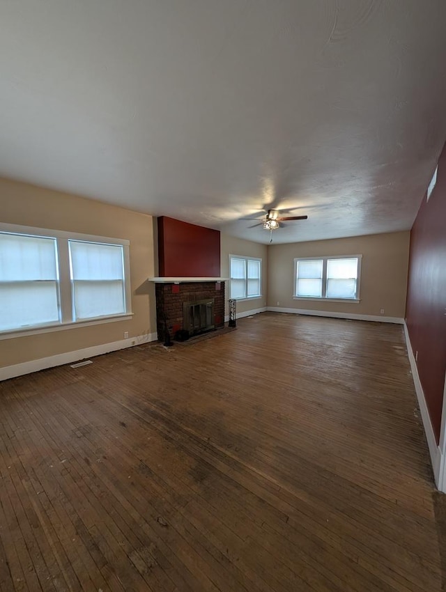 unfurnished living room with dark hardwood / wood-style floors, ceiling fan, and a fireplace