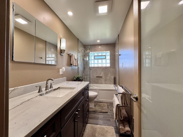 full bathroom with toilet, tiled shower / bath, and vanity