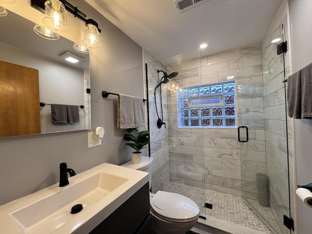 bathroom featuring toilet, an enclosed shower, and vanity