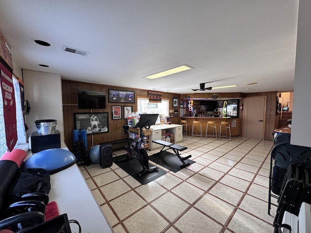 interior space with ceiling fan and wood walls