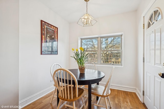 dining area with wood-type flooring and a chandelier