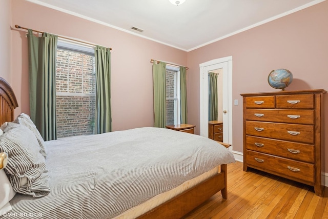 bedroom featuring ornamental molding and light wood-type flooring