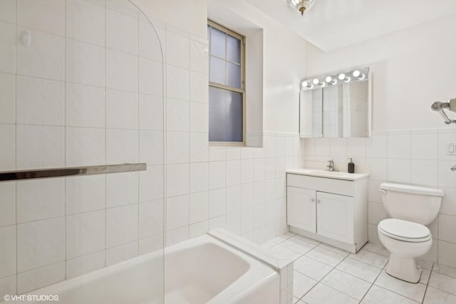 bathroom with toilet, a bathing tub, tile patterned flooring, and tile walls