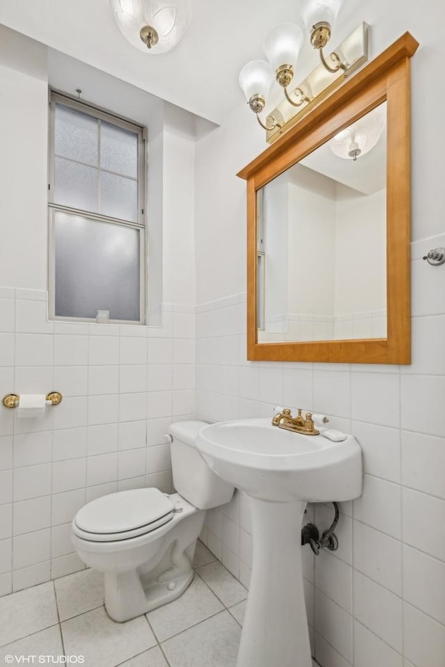 bathroom with tile patterned flooring, tile walls, and toilet