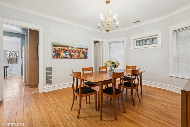 dining area featuring ornamental molding and light hardwood / wood-style flooring