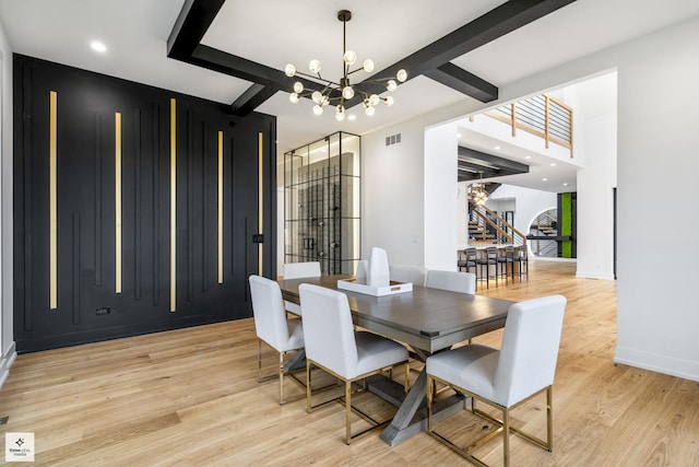 dining room featuring beam ceiling, a notable chandelier, and light wood-type flooring