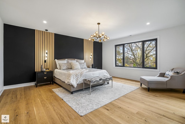 bedroom with light hardwood / wood-style floors and a notable chandelier