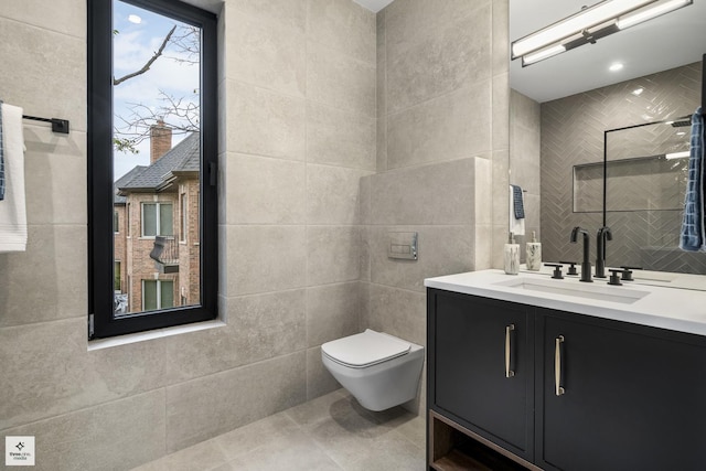 bathroom with toilet, vanity, and tile walls