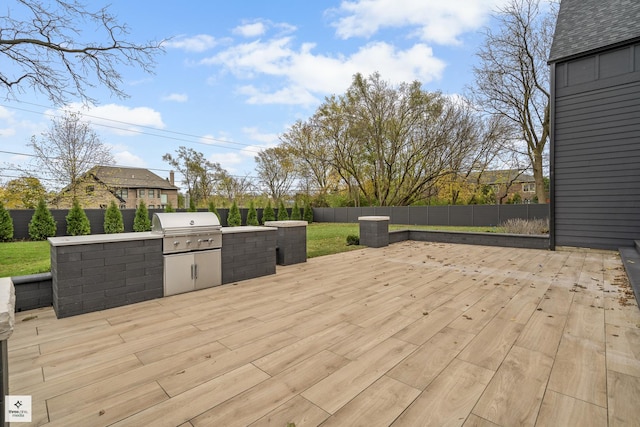 wooden deck featuring an outdoor kitchen and a grill