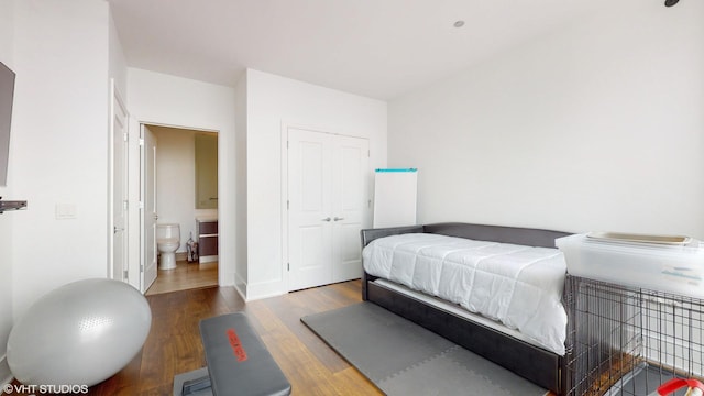 bedroom with a closet, ensuite bathroom, and hardwood / wood-style flooring