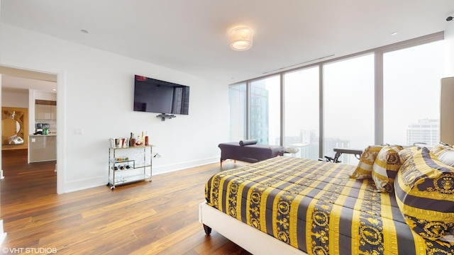 bedroom with hardwood / wood-style flooring, floor to ceiling windows, and multiple windows