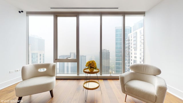 sitting room with floor to ceiling windows and wood-type flooring