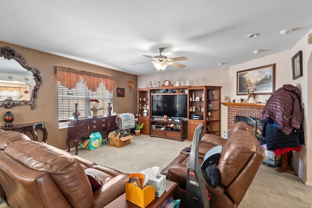 carpeted living room with ceiling fan and a fireplace