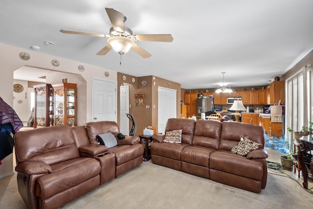 living room with light carpet and ceiling fan with notable chandelier