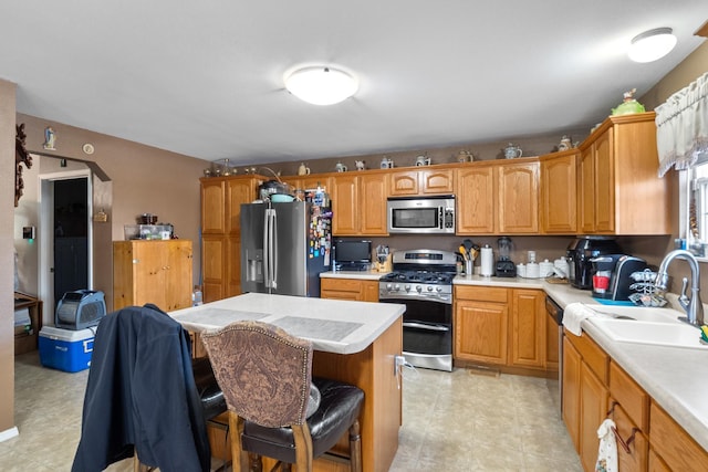 kitchen featuring a breakfast bar area, stainless steel appliances, sink, and a center island