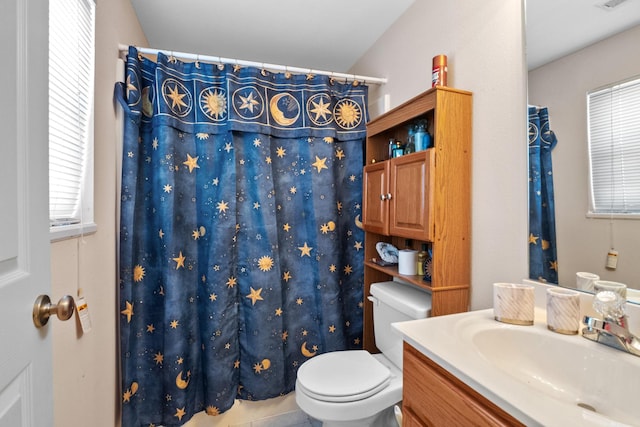 bathroom featuring toilet, tile patterned floors, vanity, and curtained shower