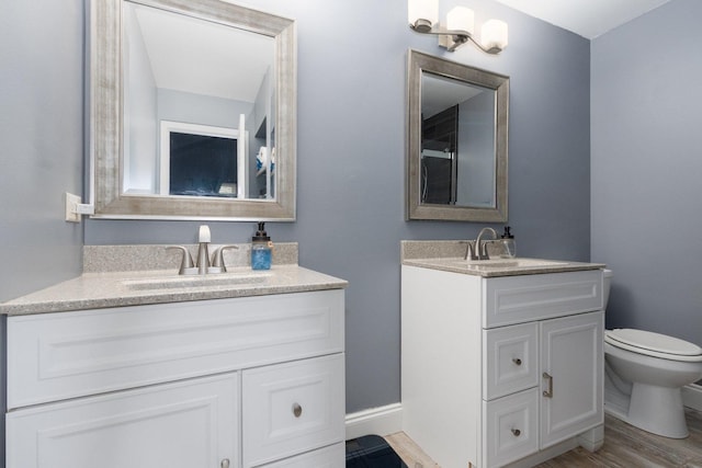 bathroom with vanity, wood-type flooring, and toilet