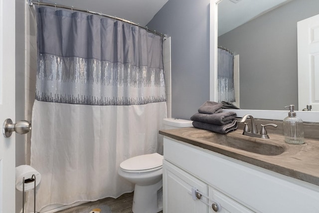 bathroom with walk in shower, vanity, and toilet