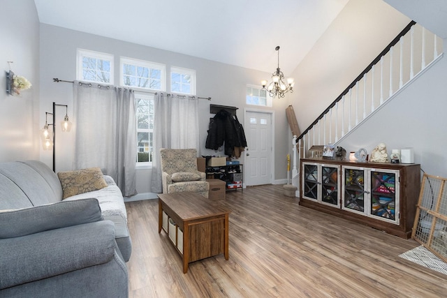 living room with high vaulted ceiling, hardwood / wood-style floors, and a notable chandelier