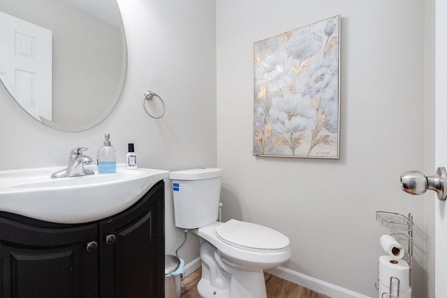 bathroom featuring vanity, wood-type flooring, and toilet