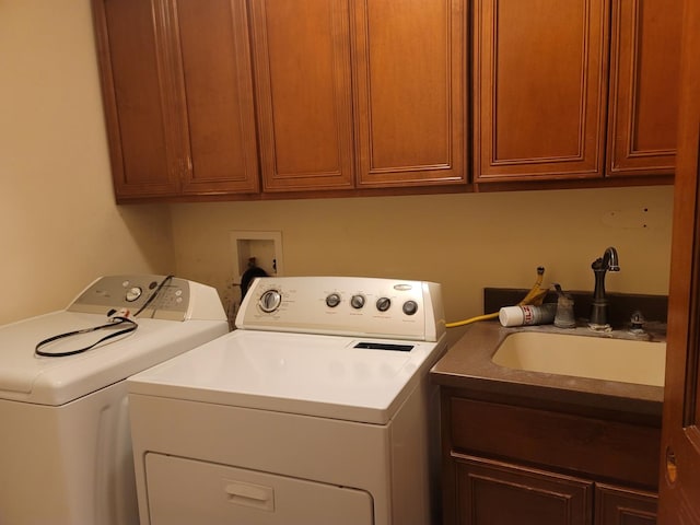 laundry area with washing machine and dryer, sink, and cabinets