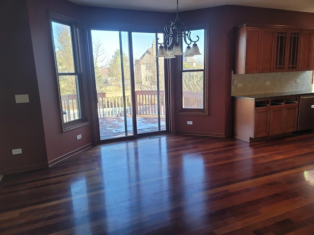 unfurnished dining area with dark hardwood / wood-style floors and an inviting chandelier