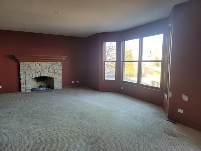 unfurnished living room featuring light carpet and a fireplace