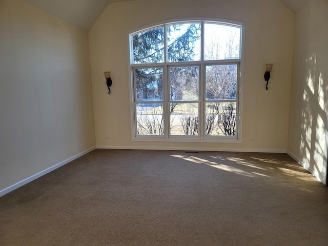 carpeted spare room with vaulted ceiling