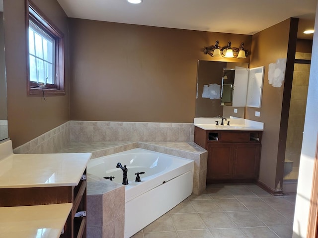 bathroom with tiled bath, tile patterned floors, and vanity