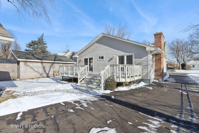 view of front of home featuring a wooden deck and a storage shed