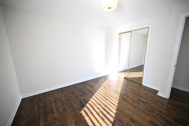 unfurnished bedroom with a closet and dark hardwood / wood-style floors