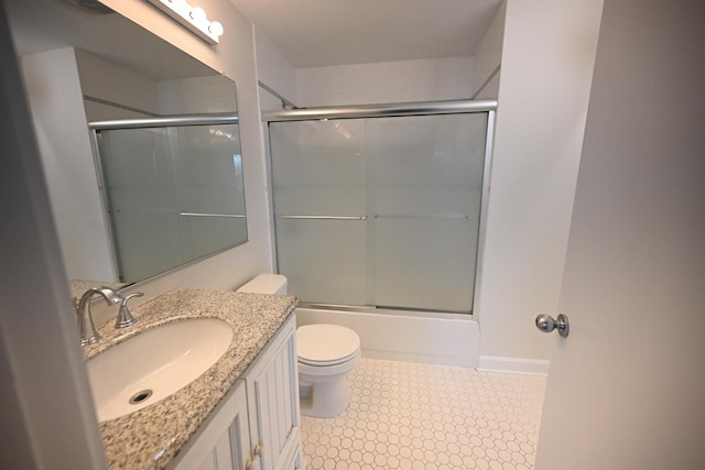 full bathroom featuring toilet, vanity, and bath / shower combo with glass door