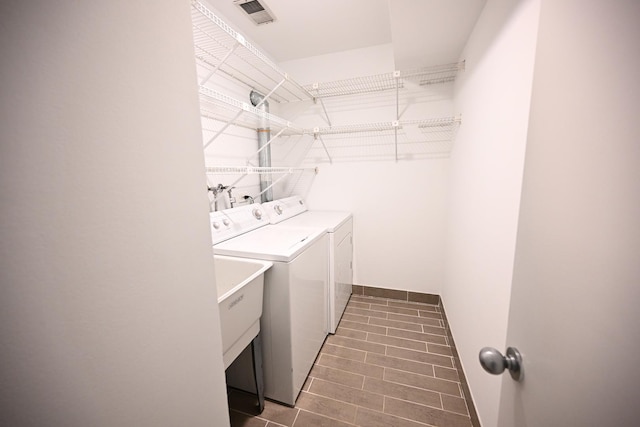 clothes washing area with sink and independent washer and dryer