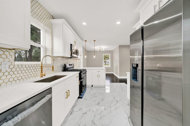 kitchen with stainless steel appliances, decorative backsplash, hanging light fixtures, white cabinets, and sink