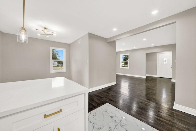 kitchen featuring an inviting chandelier, white cabinetry, pendant lighting, and dark hardwood / wood-style floors