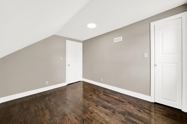 additional living space with dark wood-type flooring and lofted ceiling