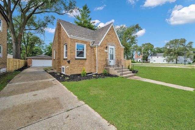 view of front of home with an outbuilding, a front yard, and a garage