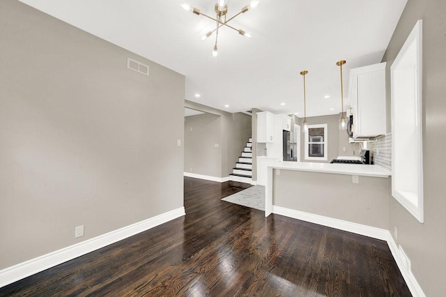 kitchen with stainless steel fridge with ice dispenser, white cabinetry, kitchen peninsula, decorative light fixtures, and wood-type flooring