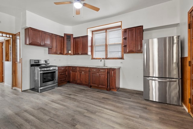 kitchen with ceiling fan, appliances with stainless steel finishes, hardwood / wood-style flooring, and sink