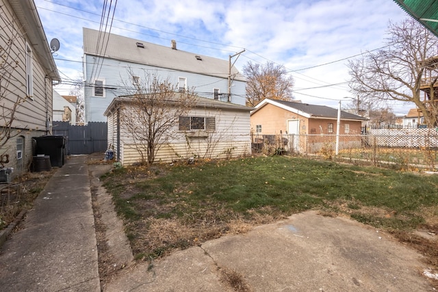 back of property with a lawn and central AC unit