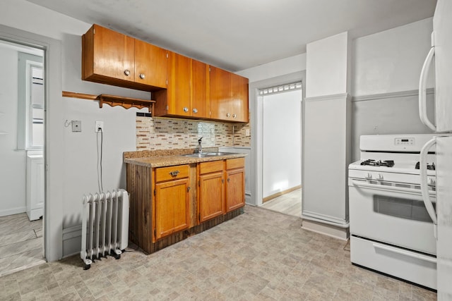 kitchen with tasteful backsplash, gas range gas stove, sink, and radiator heating unit