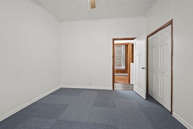 carpeted empty room featuring ceiling fan, a baseboard radiator, and crown molding