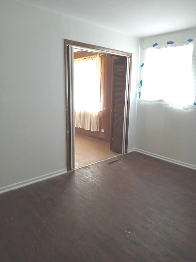 unfurnished room with dark wood-type flooring