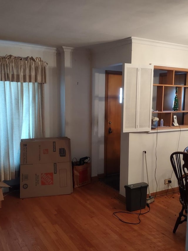 interior space featuring white cabinetry, crown molding, and hardwood / wood-style floors