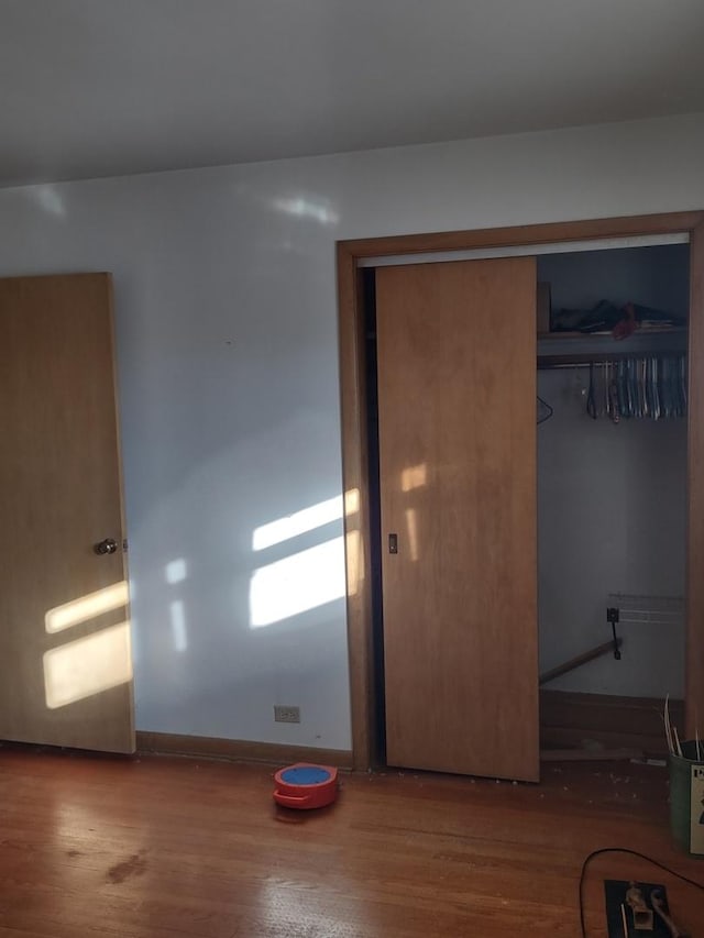 unfurnished bedroom featuring a closet and wood-type flooring